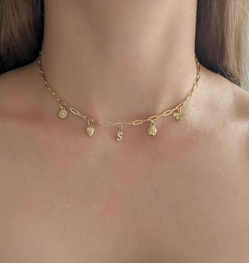 Gold necklace with small pendants on a person's neck