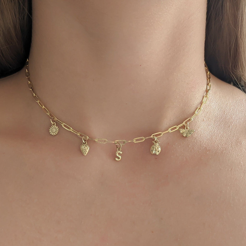 Gold necklace with small pendants on a person's neck