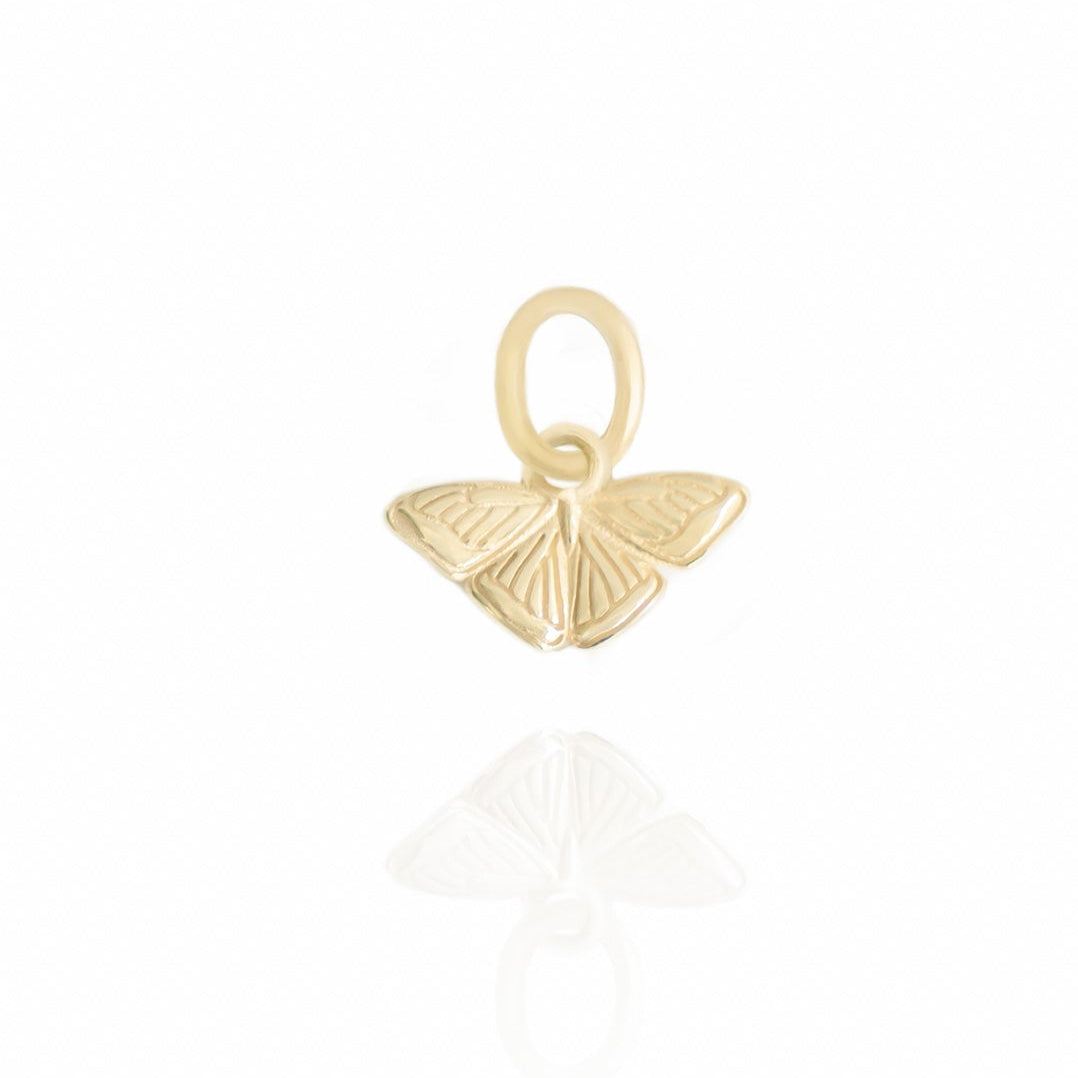 Gold butterfly pendant on a white background